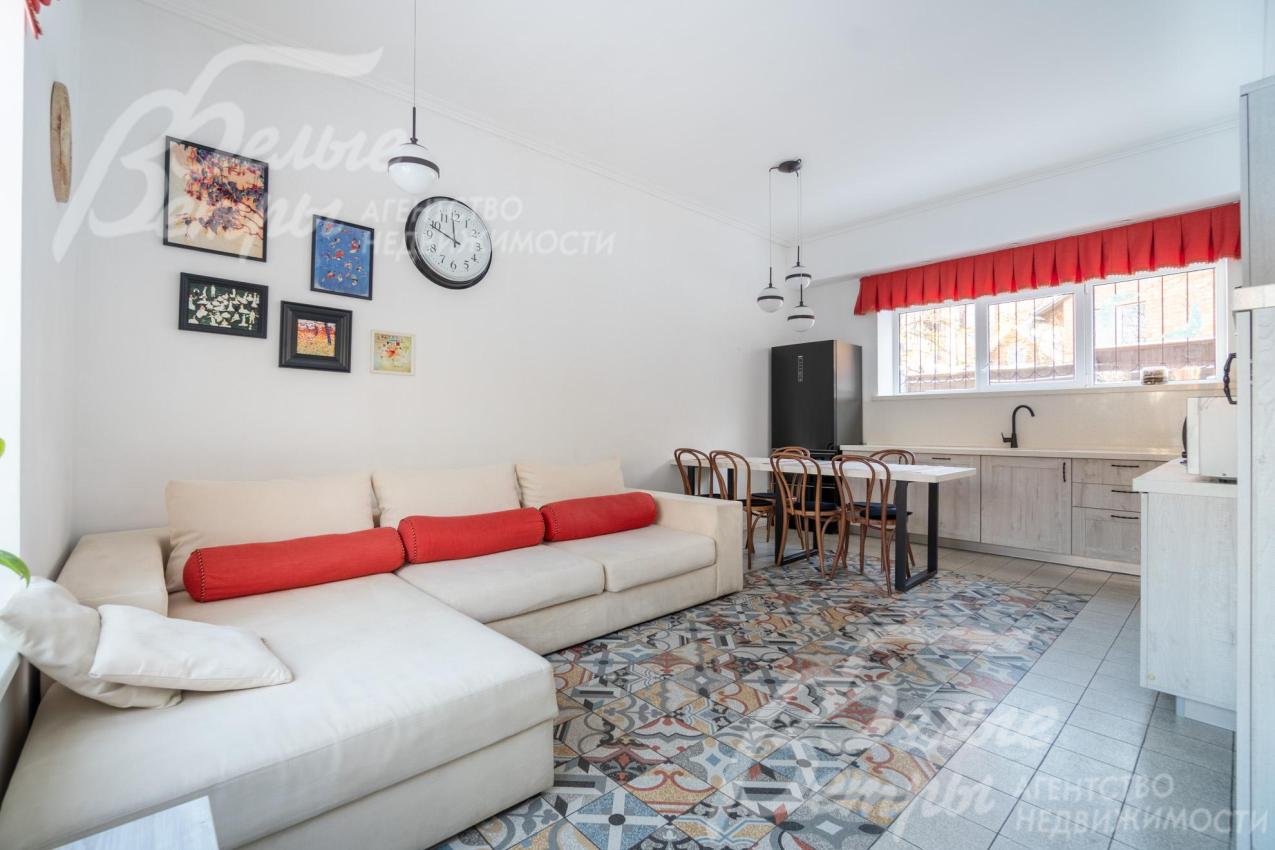 В зоне кухни-гостиной стоит большой угловой диван, а также кухонный гарнитур