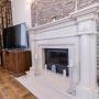 Камин облицован мрамором в классическом стиле