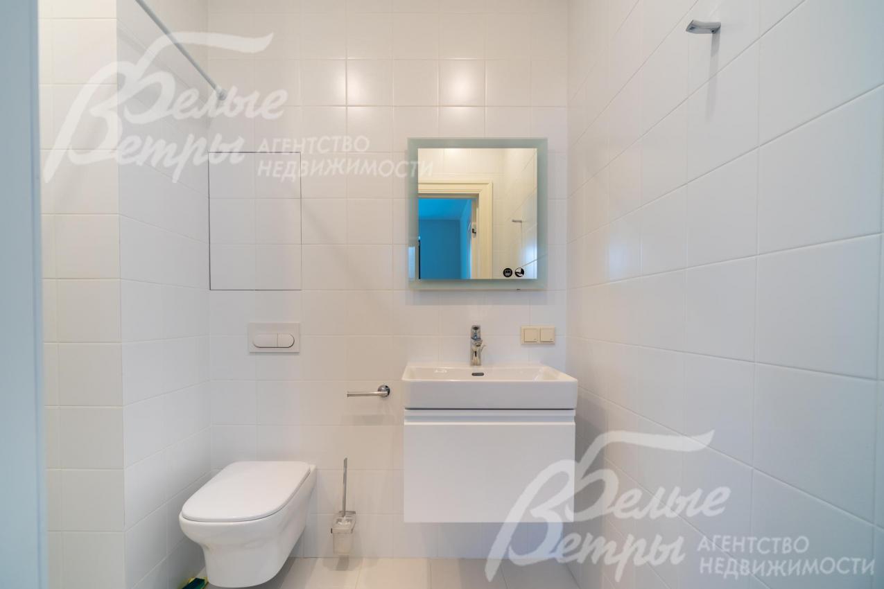 Санузел гостевого блока с белой керамической плиткой на стенах