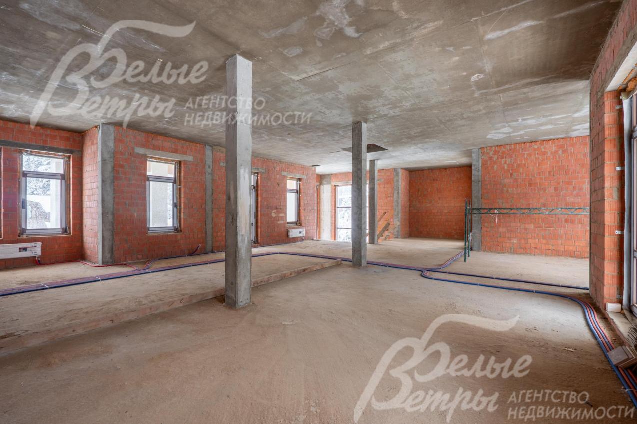 Зона кухни-столовой. Внутри дома - просторные жилые помещения, монолитные стены отделаны кирпичом