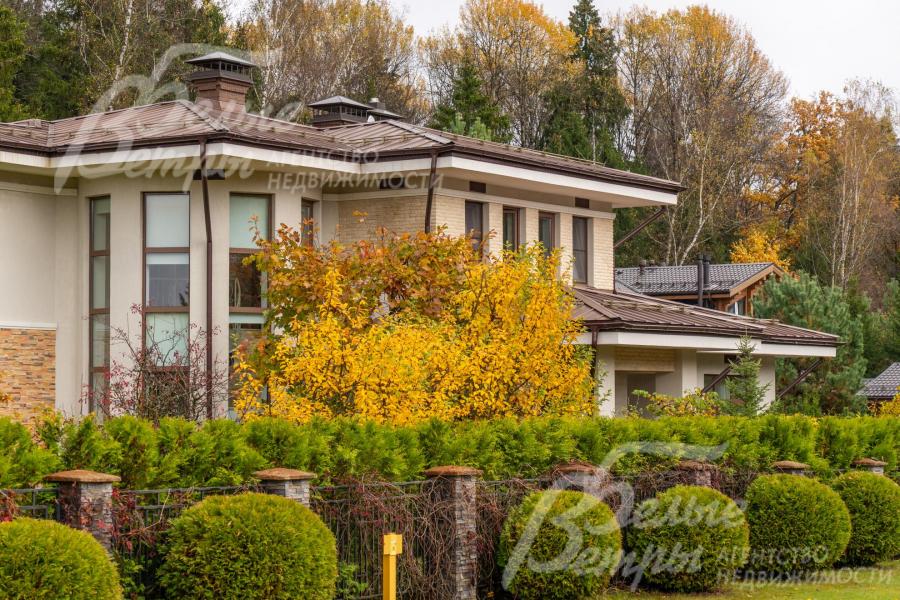 Участок огорожен забором, выполненном в едином архитектурном стиле посёлка, с кирпичными столбами и металлической конструкцией