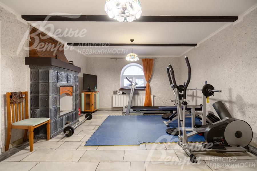 Комната на цокольном этаже со вторым камином, оборудована под спортзал 