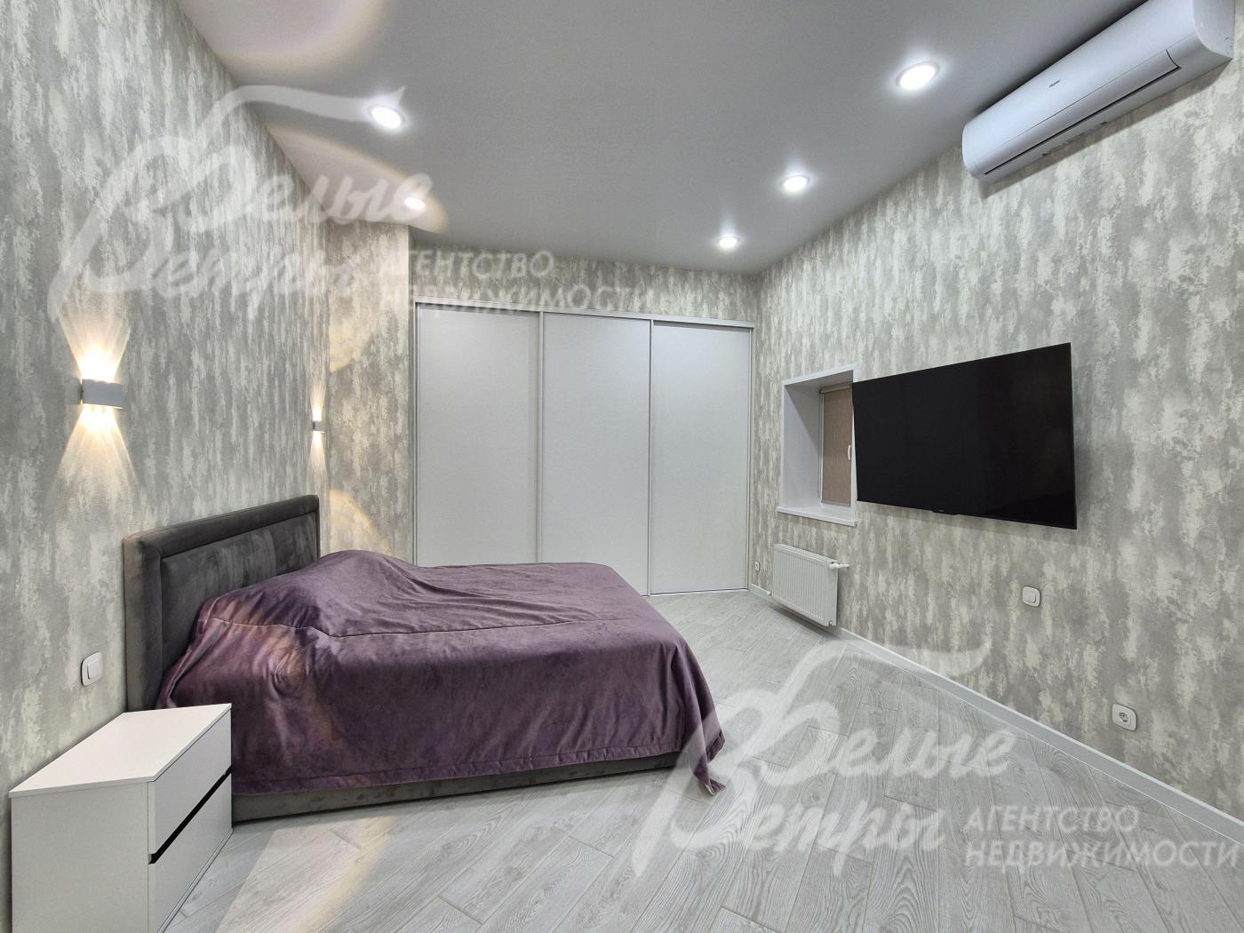 В спальне современный телевизор 65 дюймов