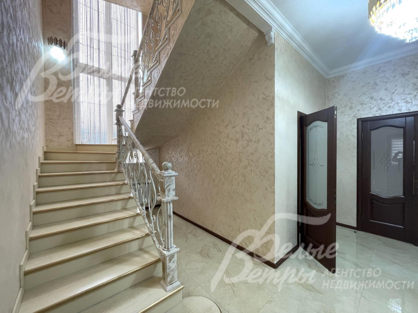 Монолитная лестница с красивыми коваными перилами