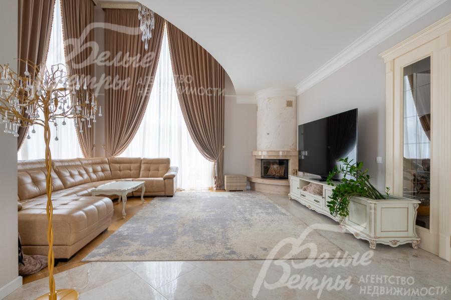 Двухсветную гостиную украшает дровяной камин гильотинного типа, установлен телевизор LG с диагональю 88 дюймов