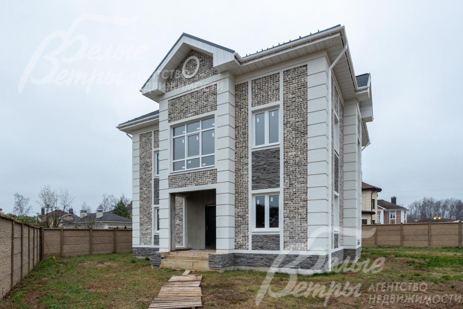 В облицовке дома сочетаются бетонная фасадная плитка, рустовка и штукатурка "короед"