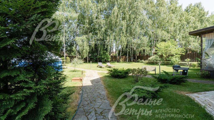 На участке растут ели, сосны, туи, яблони и кустарники