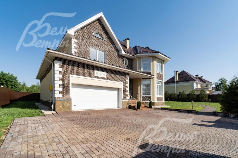 Облицовка цоколя - натуральный камень, фасады - декоративная плитка "под кирпич" (White Hills) и декоративная штукатурка с добавлением каучука