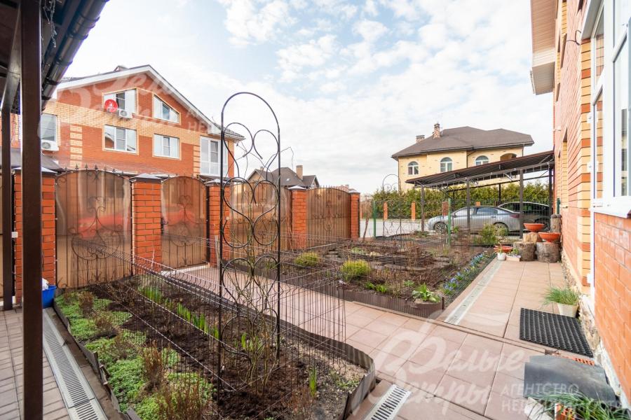 Участок облагорожен: высажен газон, дорожки вымощены плиткой