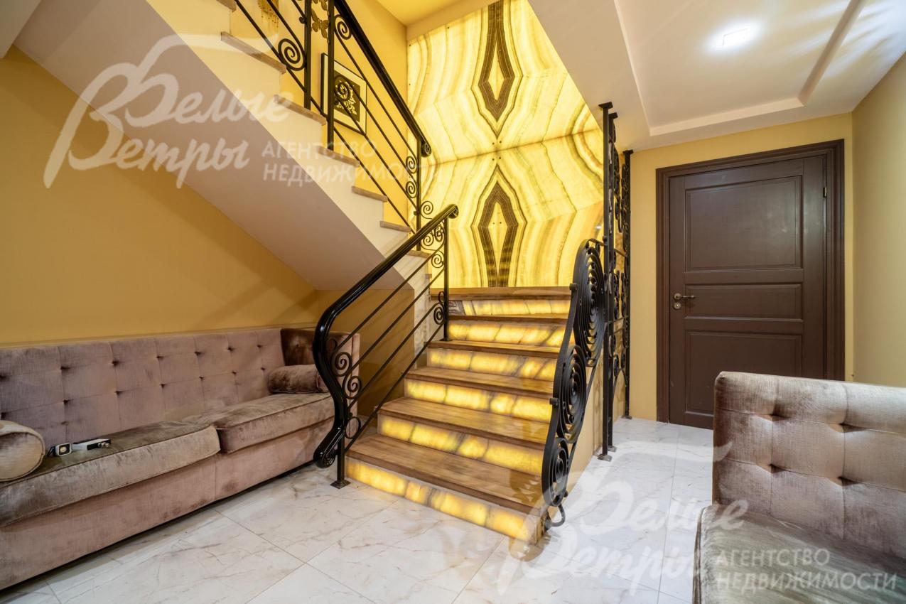 Композиционный акцент лестничного холла - панно из слэба оникса, привезённого по заказу из Италии