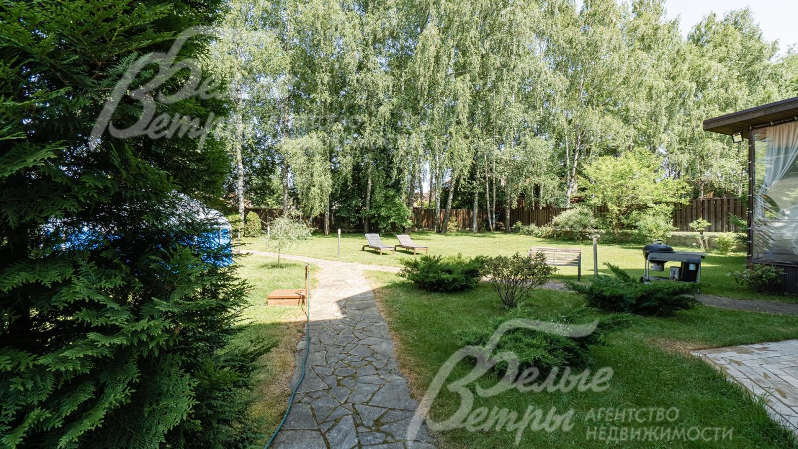 На участке растут ели, сосны, туи, яблони и кустарники