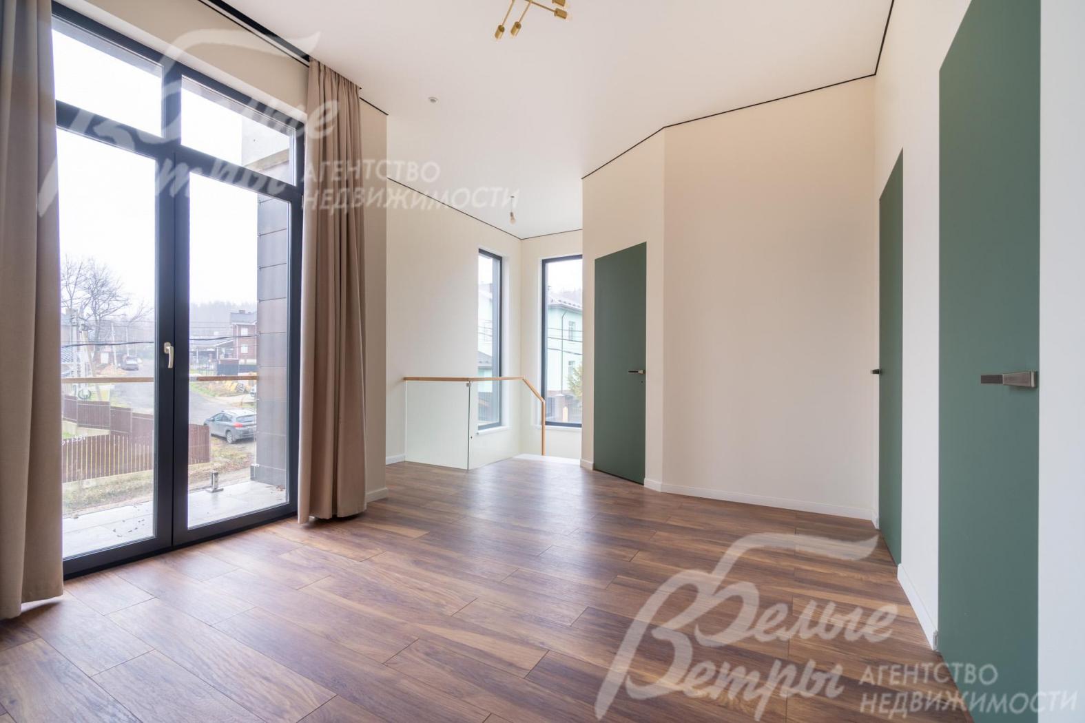 Просторный холл второго этажа с выходом на балкон