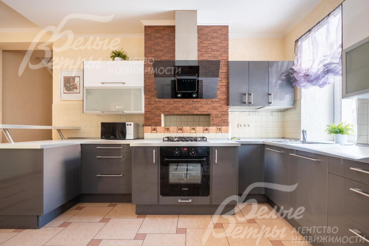 Кухонный гарнитур выполнен в тёмно-сером цвете с матовой поверхностью. В центре расположена удобная встроенная варочная панель с духовкой и вытяжкой