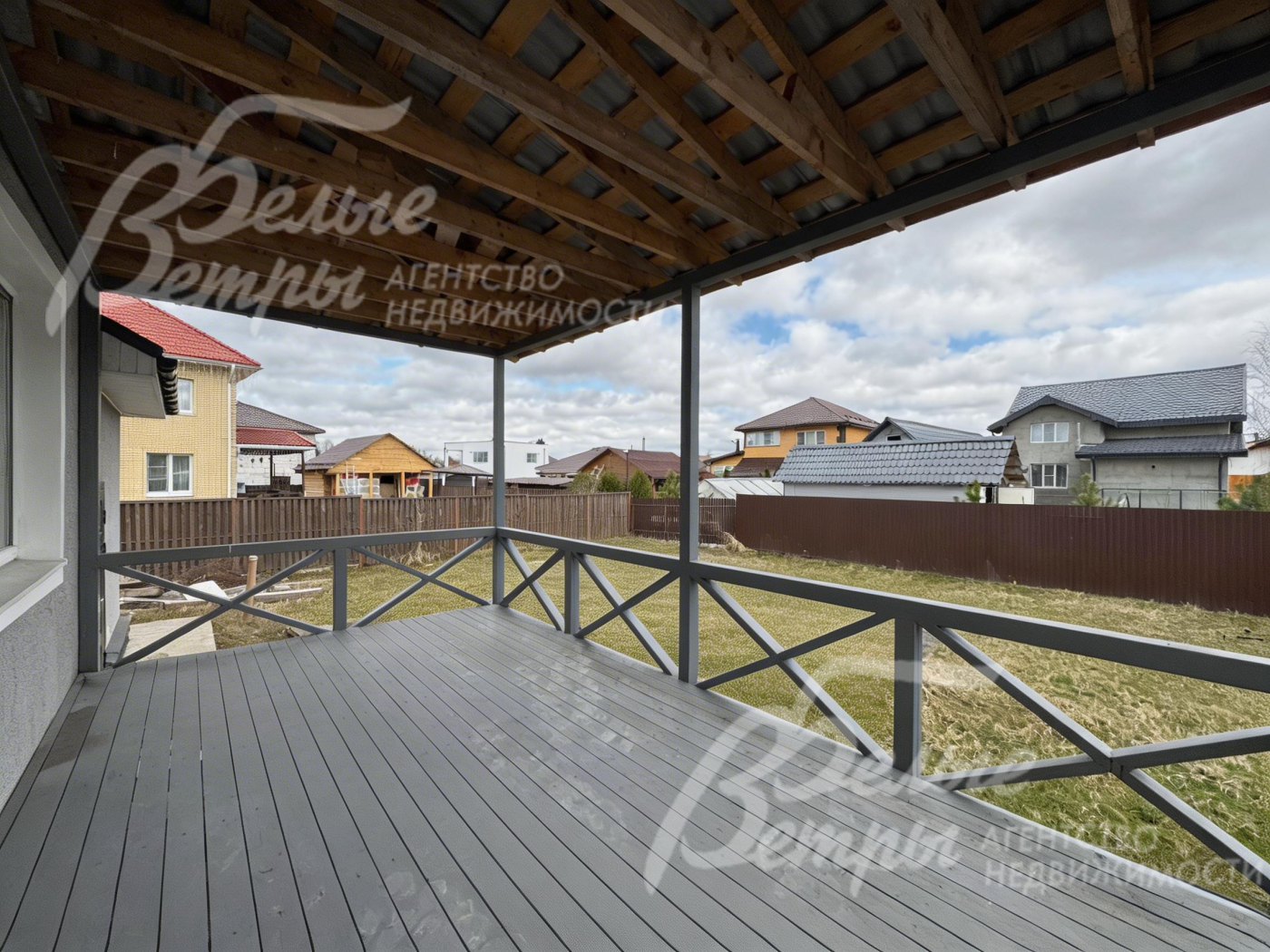 В доме есть крытая терраса с выходом на участок. пол террасы выполнен из деревянных досок серого оттенка - терраса продолжает концепцию оформления дома