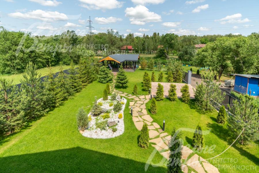 С балкона открывается панорамный вид на участок, окружающие его деревья и реку