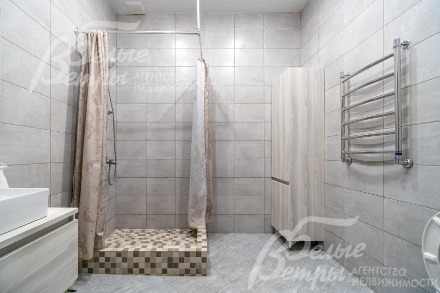 Санузел на первом этаже с душевой с отделкой в светло-серых тонах