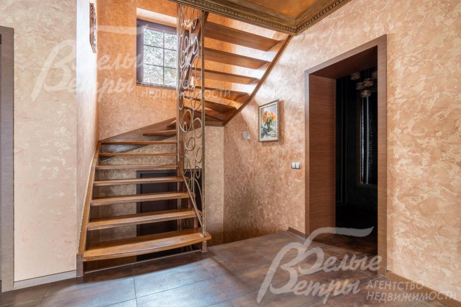 На второй этаж ведёт эффектная парящая лестница с каркасом и ступенями из массива дуба, коваными поручнями и перилами