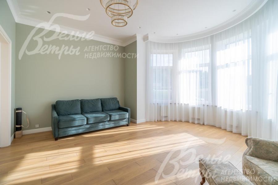 Жилая комната на 1-м этаже с эркером: окна всех комнат декорированы тюлем и шторами 