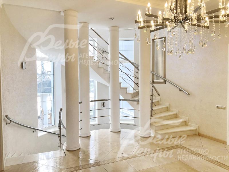 Внутри дома - красивая широкая круговая лестница, обрамленная колоннами и отделанная мрамором