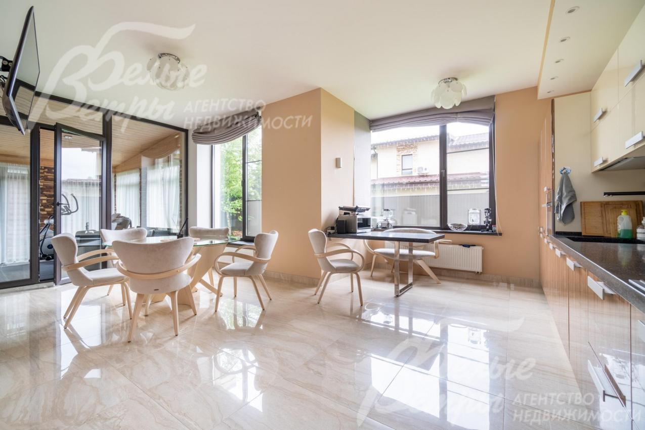 Совмещённое пространство кухни-столовой с большими окнами