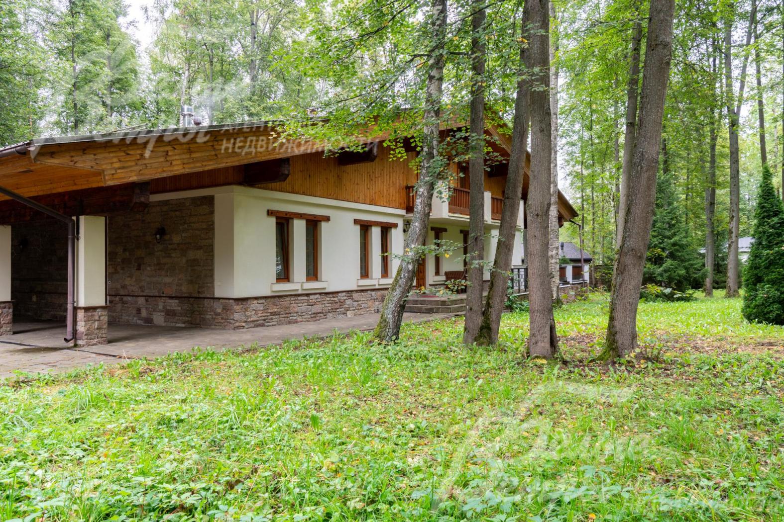 Цоколь дома отделан диким камнем, 1-й этаж - декоративной штукатуркой, 2-й этаж - лиственницей