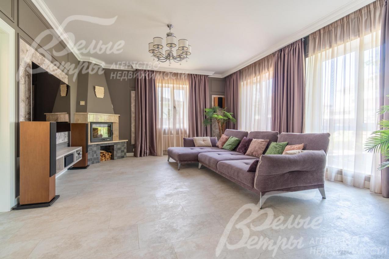 В гостиной - панорамное остекление, установлена дорогостоящая мебель, декор, ТВ-система с домашним кинотеатром