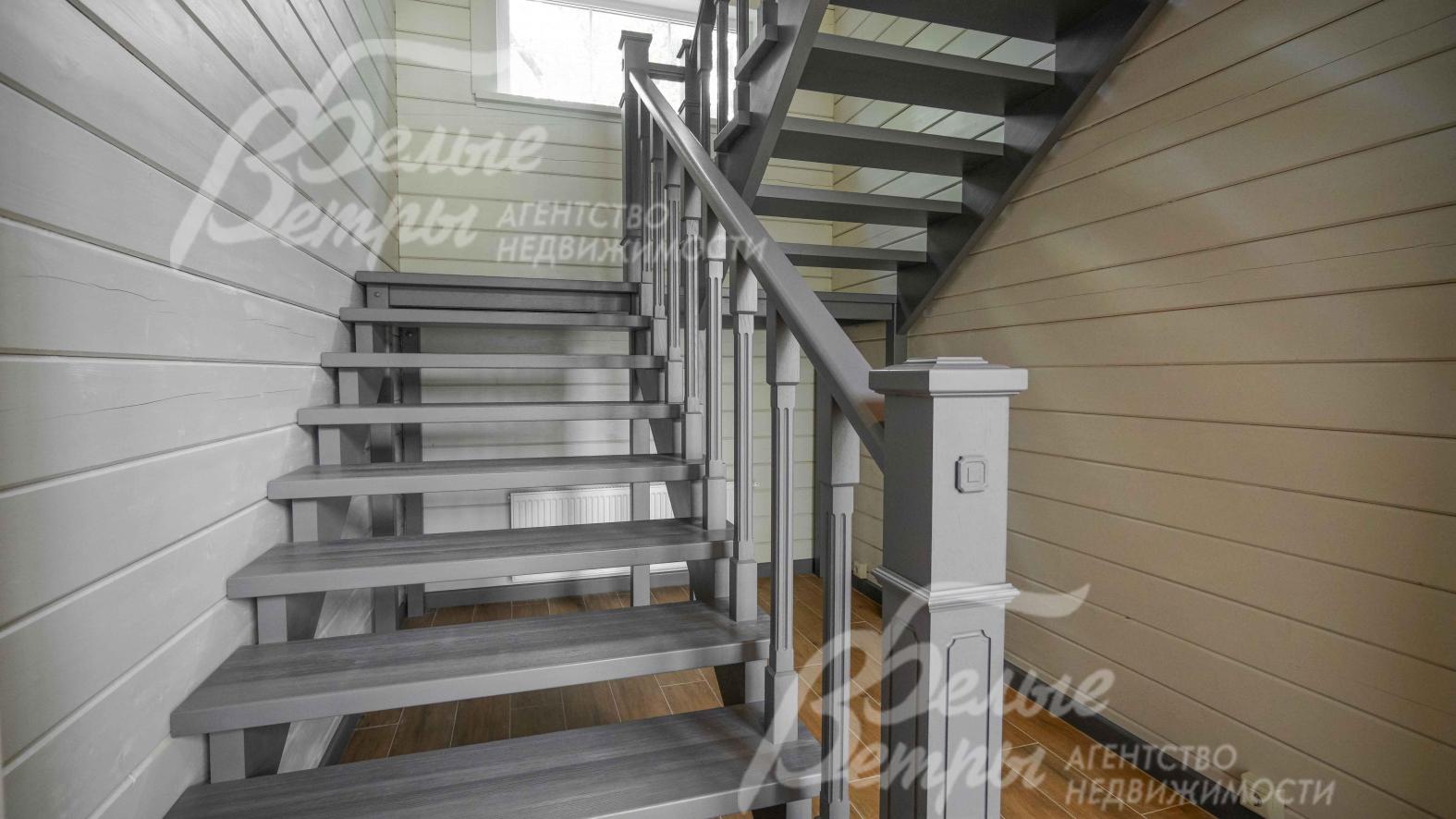 Широкая и удобная лестница из массива дуба, цвета графит. Из того же материала и той же стилистики - двери, плинтуса и кухня