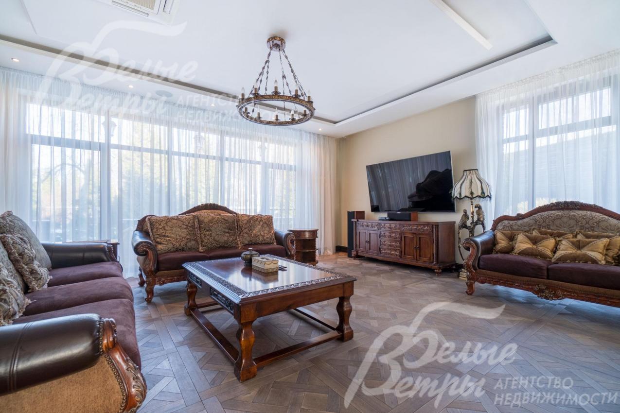 В гостиной основного дома - разноуровневые потолки, дорогостоящие люстры, дубовый паркет