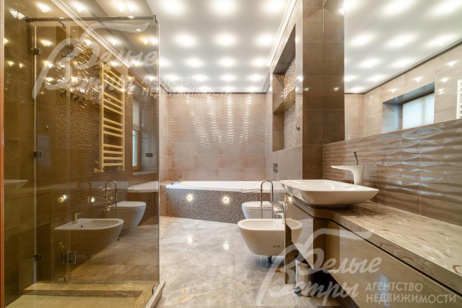 Санузел мастер-спальни - с душевой, ванной и биде, оформлен в тёплых бежевых тонах