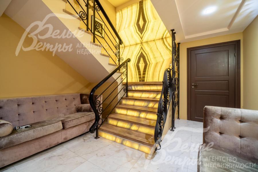 Композиционный акцент лестничного холла - панно из слэба оникса, привезённого по заказу из Италии