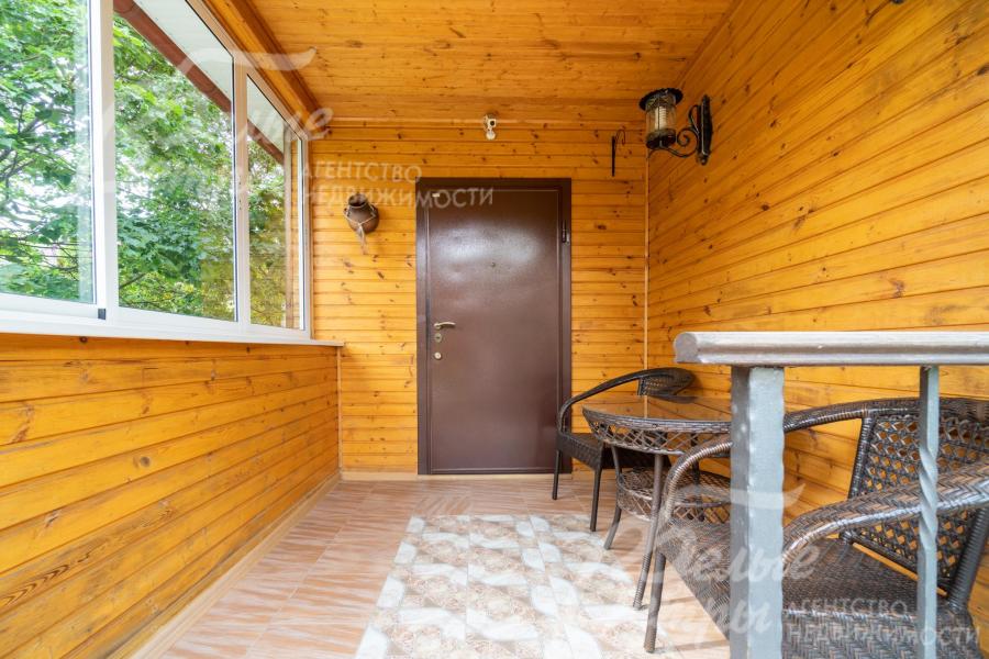 Уютное крытое застекленное крыльцо-терраса при входе в дом, с садовой мебелью