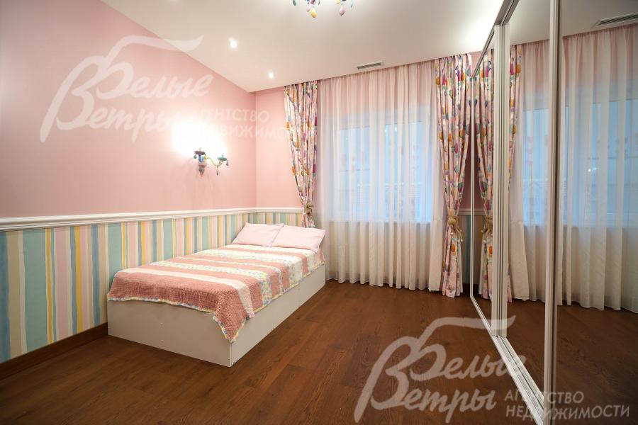 Одна из спален на первом этаже в пастельных тонах с кроватью и гардеробом