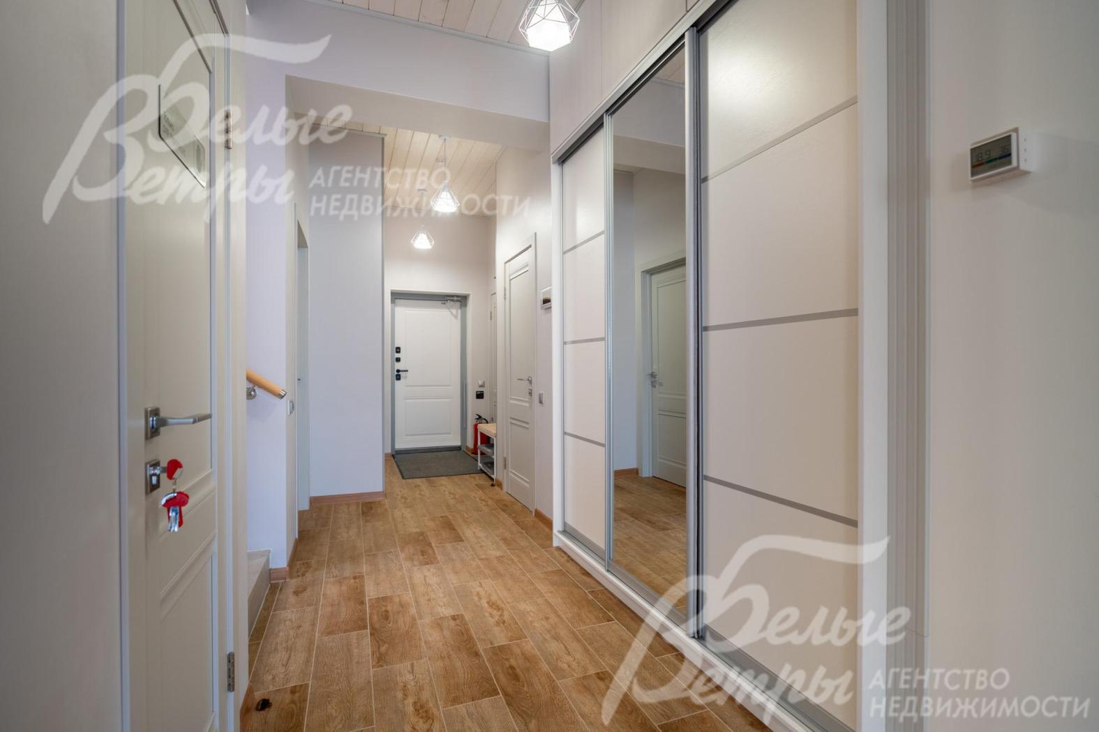 В холле находится вместительный платяной встроенный шкаф с большим зеркалом