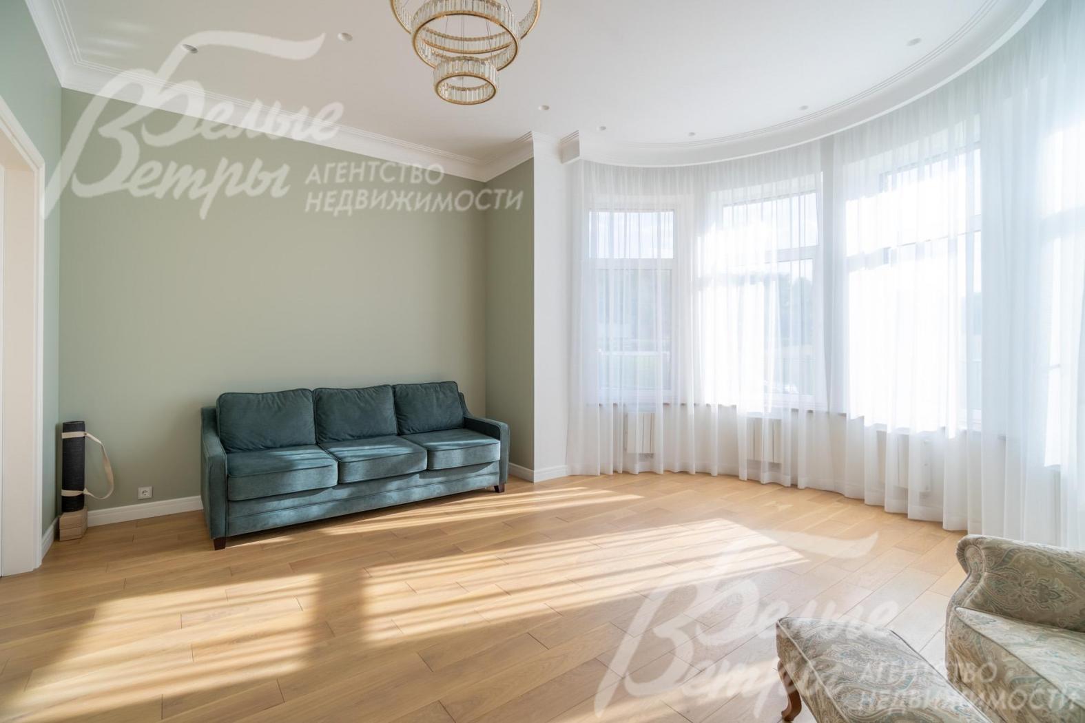 Жилая комната на 1-м этаже с эркером: окна всех комнат декорированы тюлем и шторами 