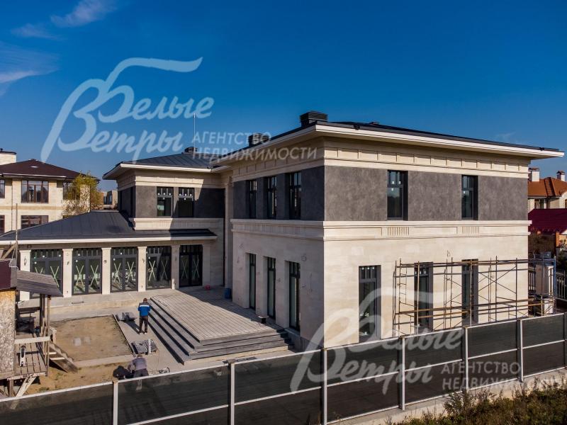 Забор отделан натуральным камнем в единой композиции дома