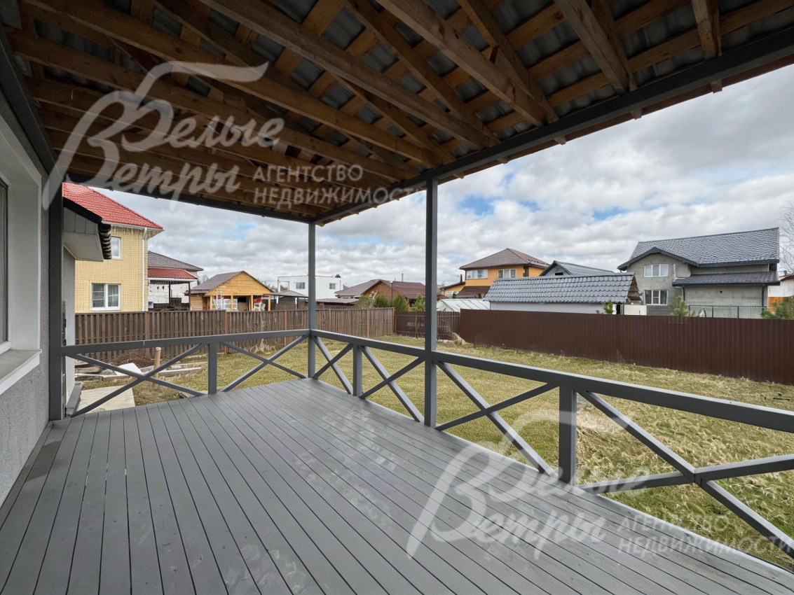 В доме есть крытая терраса с выходом на участок. пол террасы выполнен из деревянных досок серого оттенка - терраса продолжает концепцию оформления дома