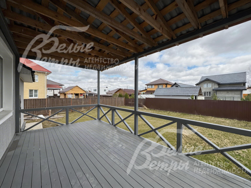 В доме есть крытая терраса с выходом на участок. пол террасы выполнен из деревянных досок серого оттенка - терраса продолжает концепцию оформления дома