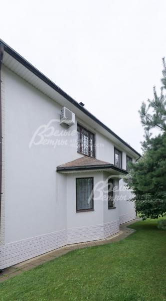 Стены дома оштукатурены в белый цвет, на всех окнах - кованые решетки