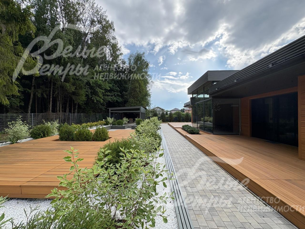 Дорожки вымощены плиткой, зоны отдыха - с покрытием из современного декинга, высажены декоративные кустарники