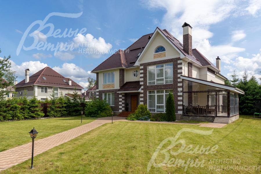 На участке высажен газон, дорожки уложены плиткой, установлены фонари