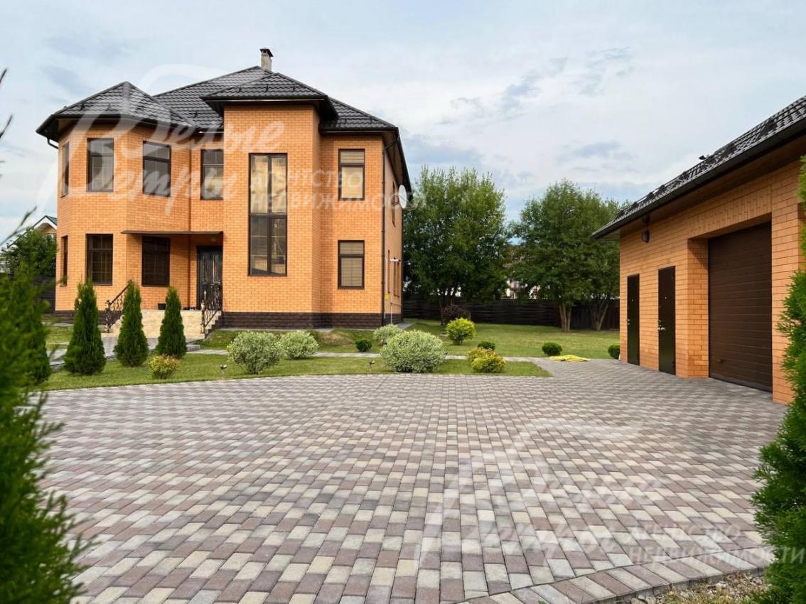 Кирпичный дом со зданием гаража на благоустроенном участке 18 соток.