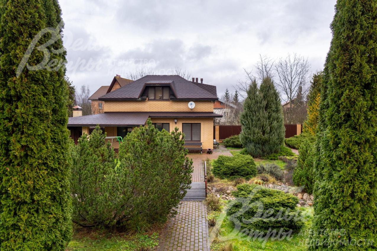 Вид на гостевой дом. По трём сторонам участок огорожен металлопрофилем на кирпичных столбах