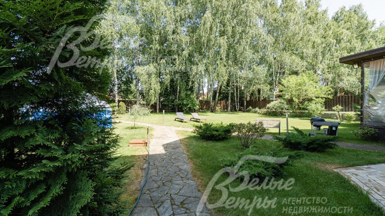 На участке растут ели, сосны, туи, яблони и кустарники