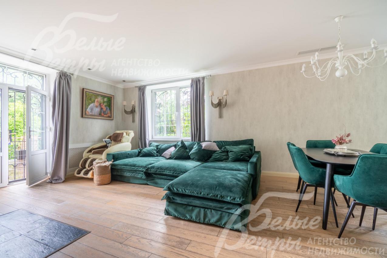 Объединённое пространство гостиной и кухни-столовой в светлых тонах с контрастной акцентной мебелью