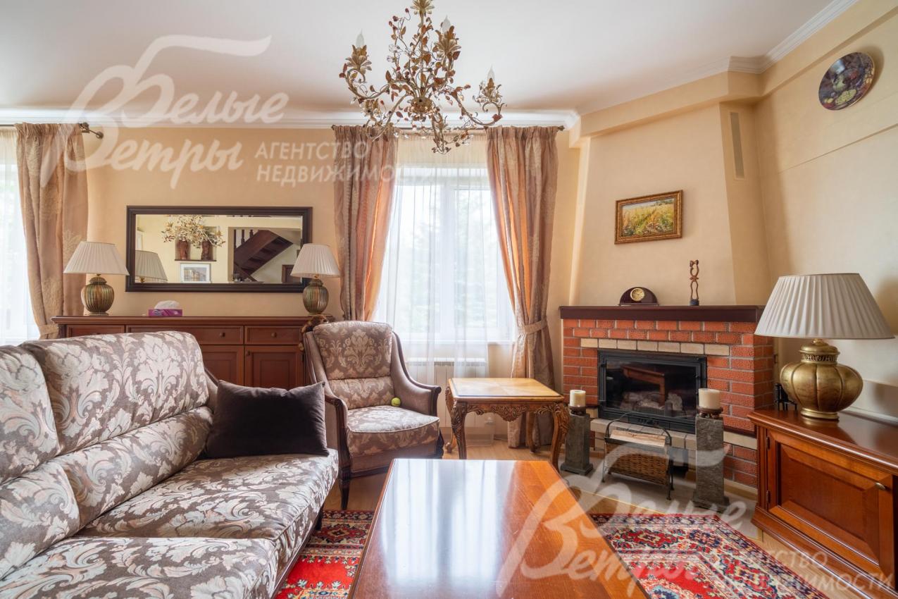 Гостиную украшает дровяной камин и итальянская люстра