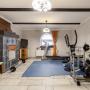 Комната на цокольном этаже со вторым камином, оборудована под спортзал 