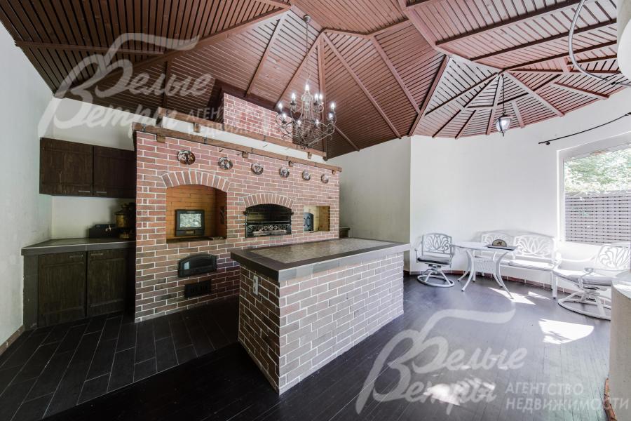 Отдельностоящая рядом с уютным прудом беседка-барбекю с мангалом и двумя видами печей