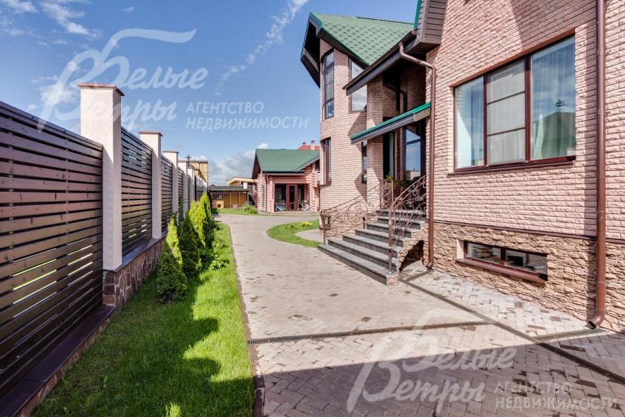 Участок огорожен двойным деревянным забором на каменных столбах