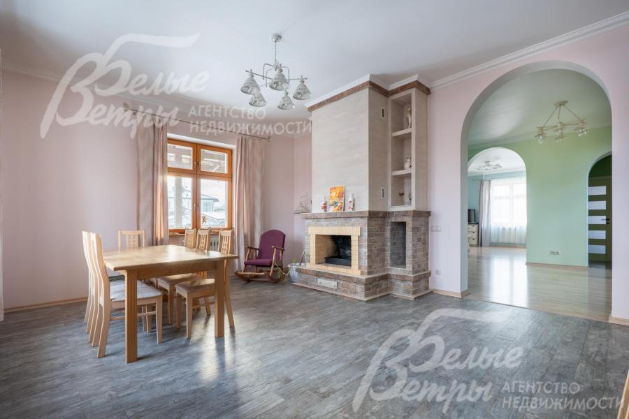 Зона кухни-столовой. Столовую украшает дровяной камин, рядом - кресло-качалка