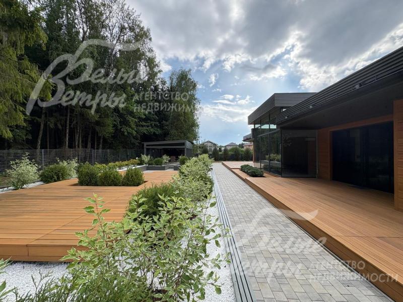 Дорожки вымощены плиткой, зоны отдыха - с покрытием из современного декинга, высажены декоративные кустарники